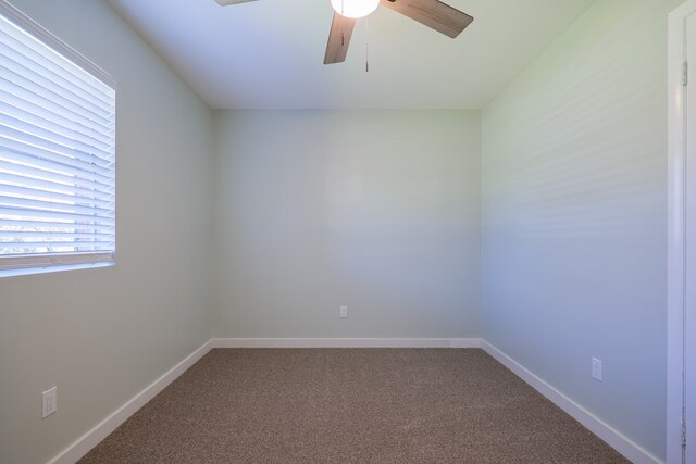 carpeted spare room featuring ceiling fan