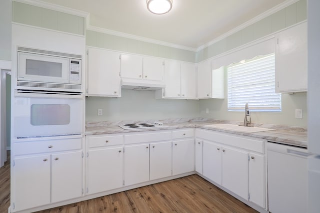 kitchen featuring white appliances, white cabinetry, crown molding, and sink