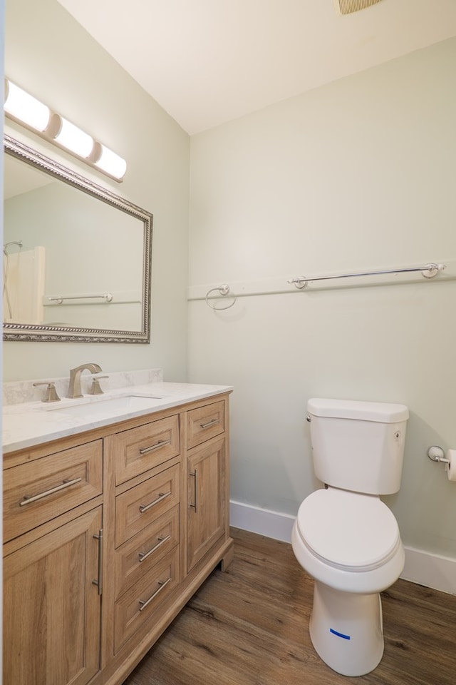 bathroom featuring vanity, toilet, and wood-type flooring