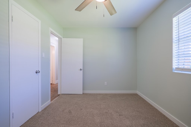 unfurnished room featuring ceiling fan, a healthy amount of sunlight, and light carpet