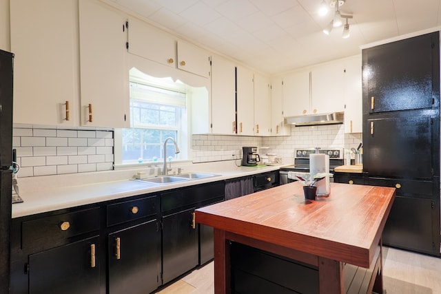 kitchen with sink, tasteful backsplash, light hardwood / wood-style flooring, stainless steel electric stove, and white cabinets