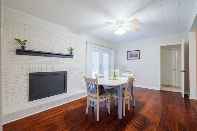 dining room with a fireplace, crown molding, dark wood-type flooring, and ceiling fan