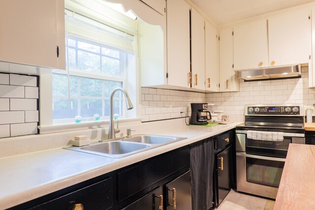 kitchen with double oven range, backsplash, sink, and white cabinets