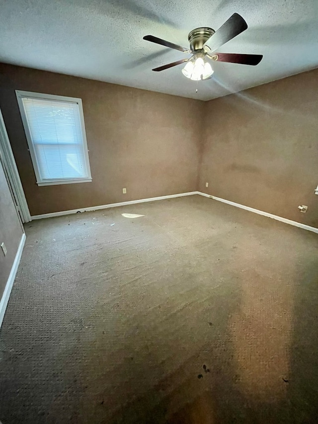 carpeted empty room with baseboards, a textured ceiling, and a ceiling fan