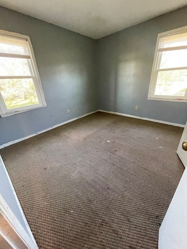 carpeted empty room with baseboards