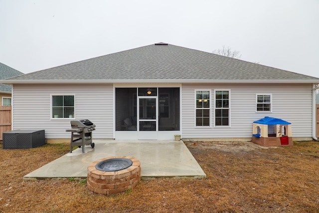 rear view of house featuring a sunroom, a patio, and a fire pit