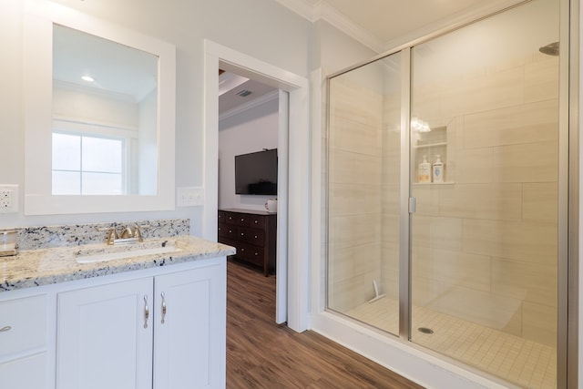 bathroom with vanity, hardwood / wood-style floors, crown molding, and a shower with shower door