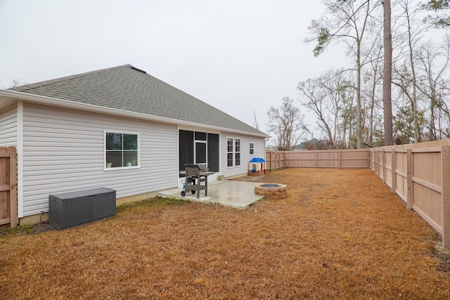 rear view of house featuring a patio, a lawn, and an outdoor fire pit