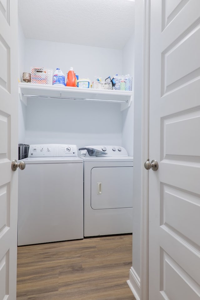 washroom with wood-type flooring and separate washer and dryer