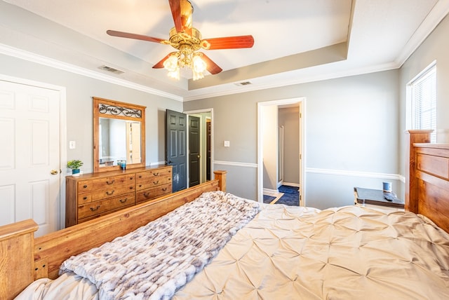 bedroom featuring crown molding, a raised ceiling, and ceiling fan