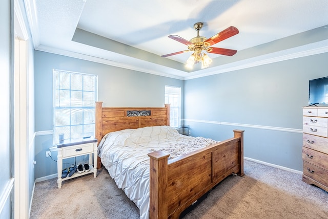 carpeted bedroom featuring a raised ceiling, crown molding, and ceiling fan