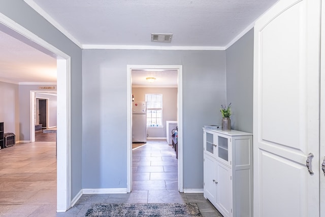 hall featuring ornamental molding, a textured ceiling, and light tile patterned floors