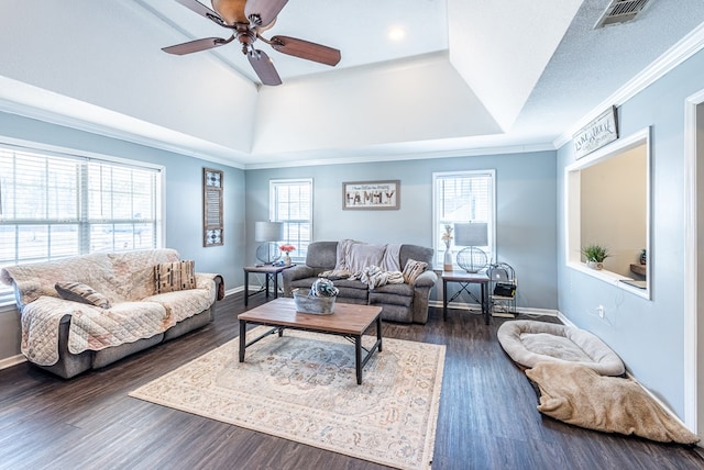 living room featuring ceiling fan, a tray ceiling, ornamental molding, a textured ceiling, and dark hardwood / wood-style flooring