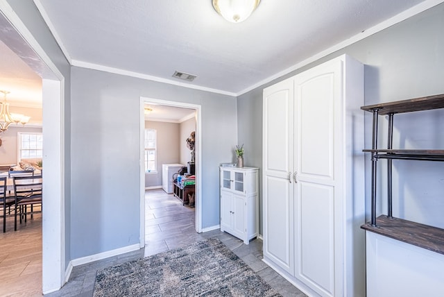 hall featuring an inviting chandelier and crown molding