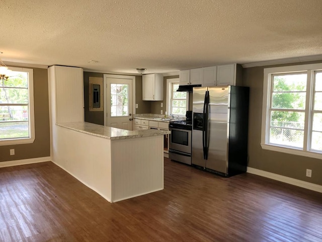 kitchen with white cabinets, stainless steel appliances, kitchen peninsula, and dark hardwood / wood-style floors