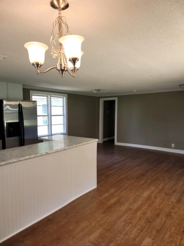 kitchen featuring pendant lighting, stainless steel fridge, a textured ceiling, dark hardwood / wood-style flooring, and a chandelier