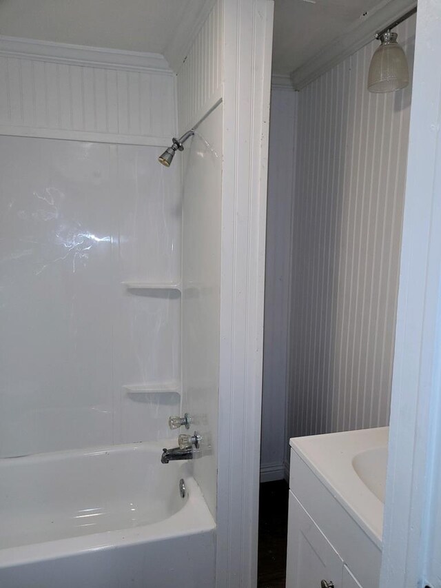 bathroom with shower / bathing tub combination, vanity, and ornamental molding