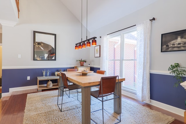 dining area featuring lofted ceiling, baseboards, and wood finished floors