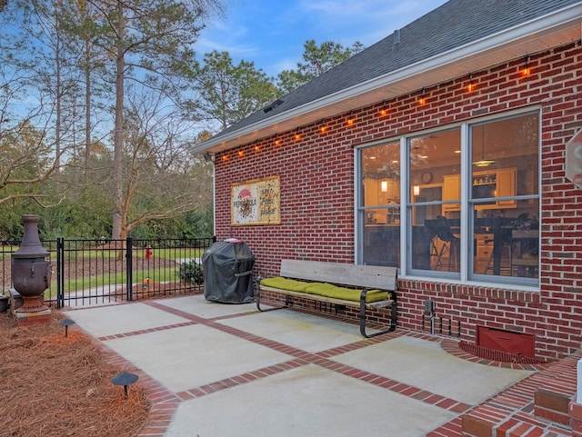 view of patio featuring a grill, a gate, and fence