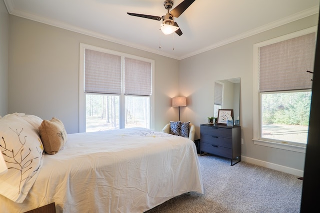 carpeted bedroom featuring ornamental molding, a ceiling fan, and baseboards