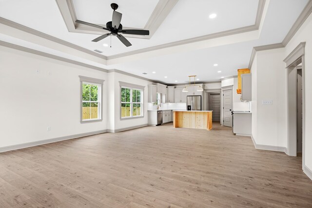 2204 N Oak St, Valdosta, GA 31602 - unfurnished living room featuring a tray ceiling, crown molding, ceiling fan, light wood-style flooring, and recessed lighting