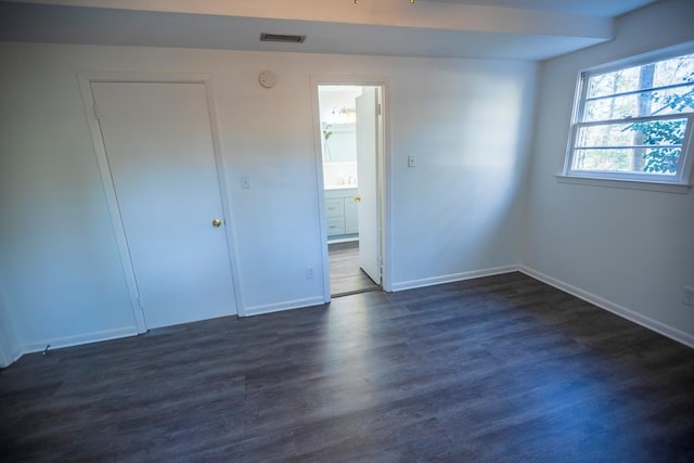 2205 Park Ln, Valdosta, GA 31602 - unfurnished bedroom featuring baseboards, visible vents, dark wood-style flooring, and ensuite bathroom