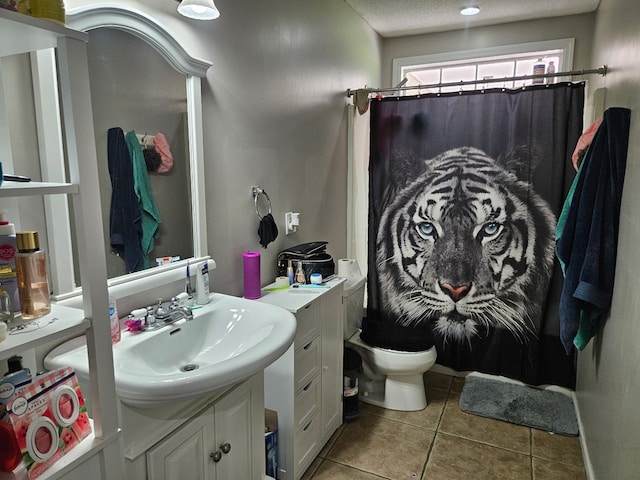 full bath with tile patterned flooring, vanity, toilet, a shower with shower curtain, and a textured ceiling