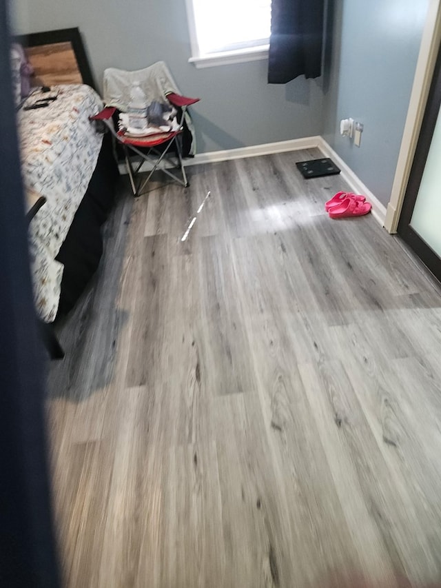 bedroom with baseboards and wood finished floors