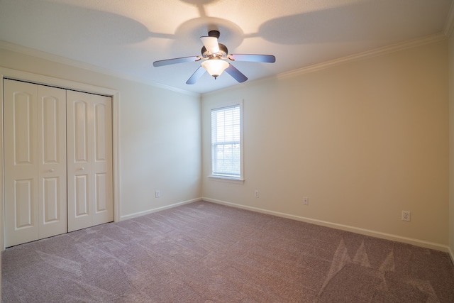 unfurnished bedroom with baseboards, ceiling fan, ornamental molding, carpet, and a closet