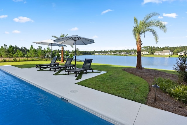 view of pool with a yard and a water view