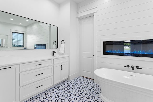 bathroom featuring a bath, vanity, and wooden walls