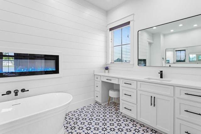 bathroom with a washtub, vanity, and wood walls