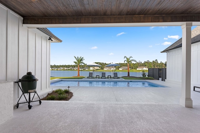 view of swimming pool featuring a water view and a patio