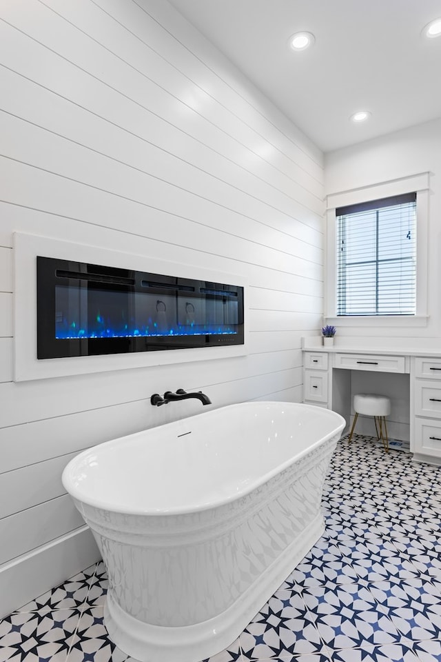 bathroom featuring a tub to relax in and wooden walls