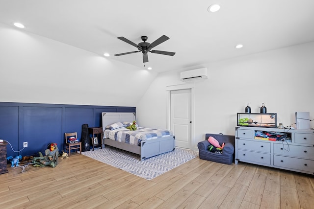 bedroom featuring a wall mounted air conditioner, ceiling fan, light hardwood / wood-style floors, and vaulted ceiling