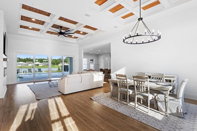 dining room with coffered ceiling, hardwood / wood-style floors, beamed ceiling, and ceiling fan with notable chandelier