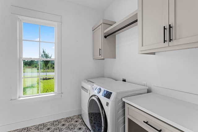 laundry room with cabinets, washing machine and dryer, and tile patterned flooring