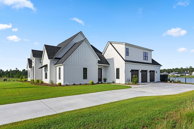 modern farmhouse featuring a garage and a front lawn