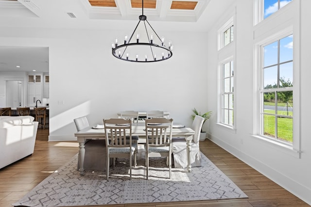 dining room with a chandelier, ornamental molding, plenty of natural light, and dark wood-type flooring