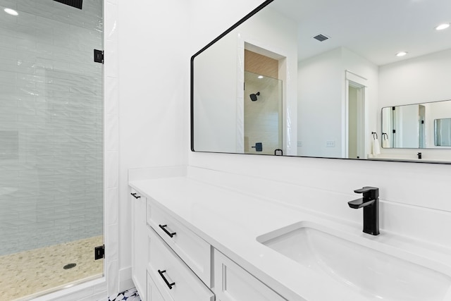 bathroom with vanity and a shower with door