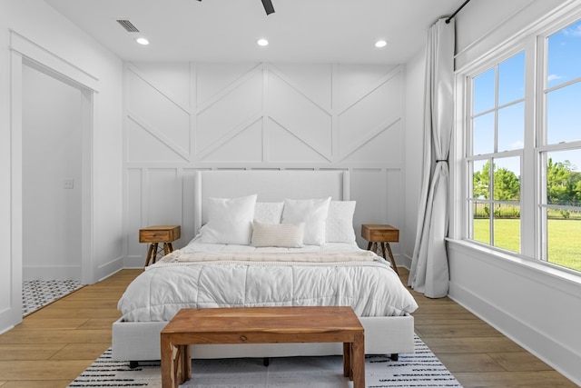 bedroom featuring hardwood / wood-style flooring, multiple windows, and ceiling fan