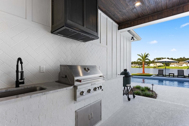 view of patio / terrace with area for grilling, a water view, sink, and grilling area