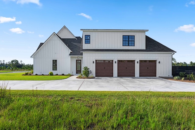 modern inspired farmhouse with a garage and a front lawn