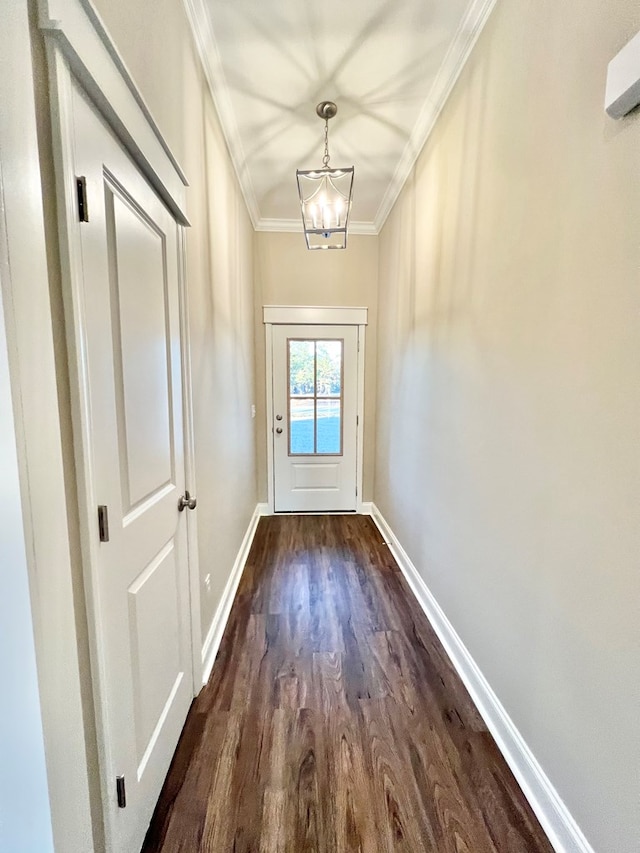 entryway featuring ornamental molding, an inviting chandelier, and dark wood-type flooring