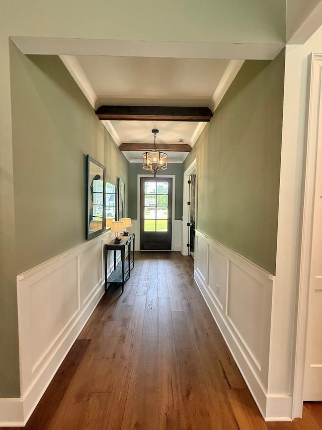 entryway featuring dark wood-style flooring, a decorative wall, beam ceiling, and a notable chandelier