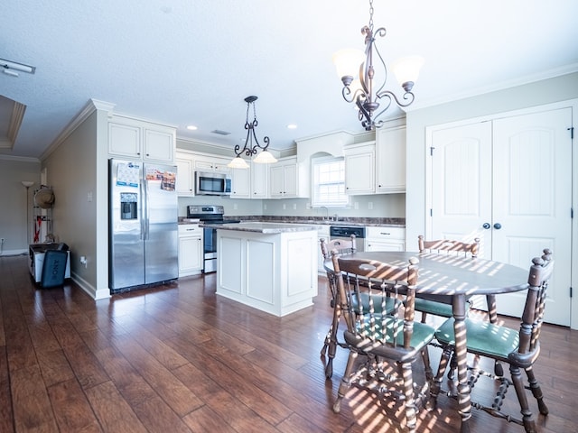 kitchen with a kitchen island, white cabinetry, sink, hanging light fixtures, and stainless steel appliances