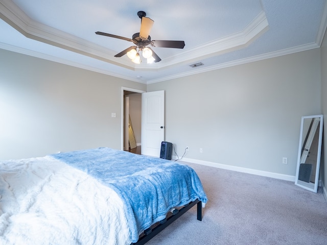 bedroom with crown molding, carpet flooring, ceiling fan, and a tray ceiling