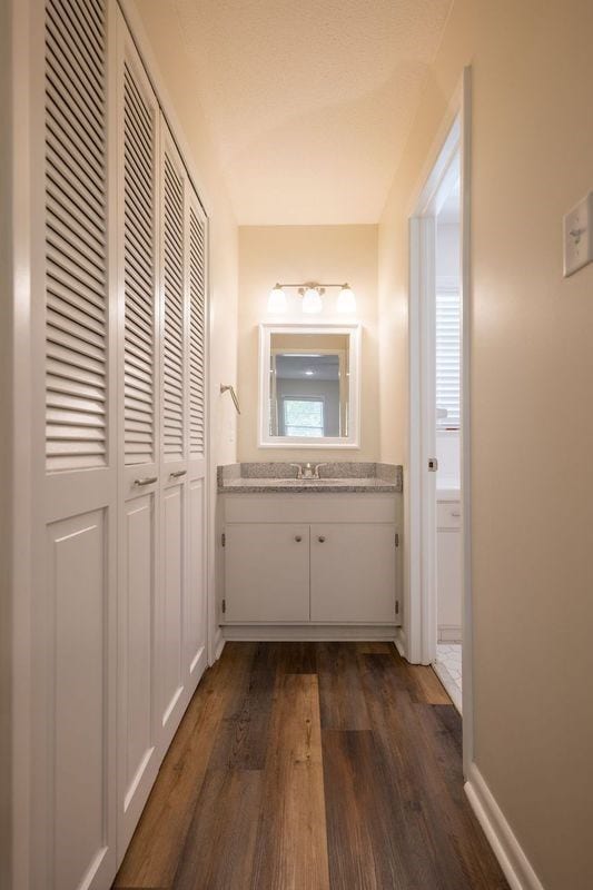 hall with dark hardwood / wood-style flooring and sink