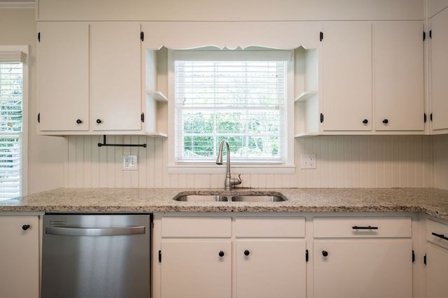 kitchen featuring light stone counters, sink, white cabinets, and dishwasher