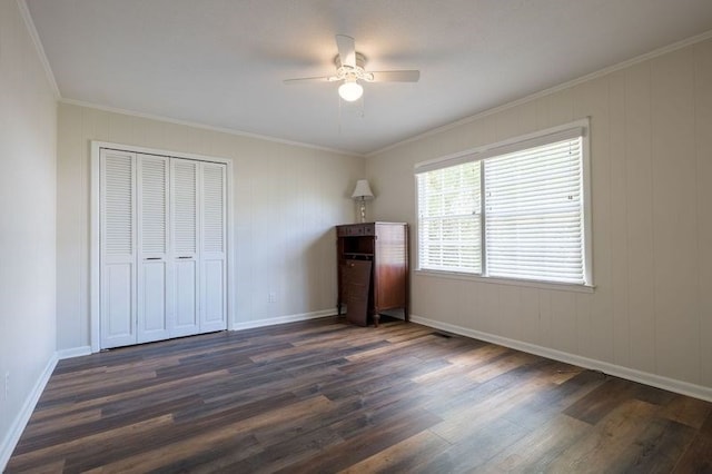 unfurnished bedroom featuring ceiling fan, a closet, dark hardwood / wood-style floors, and crown molding